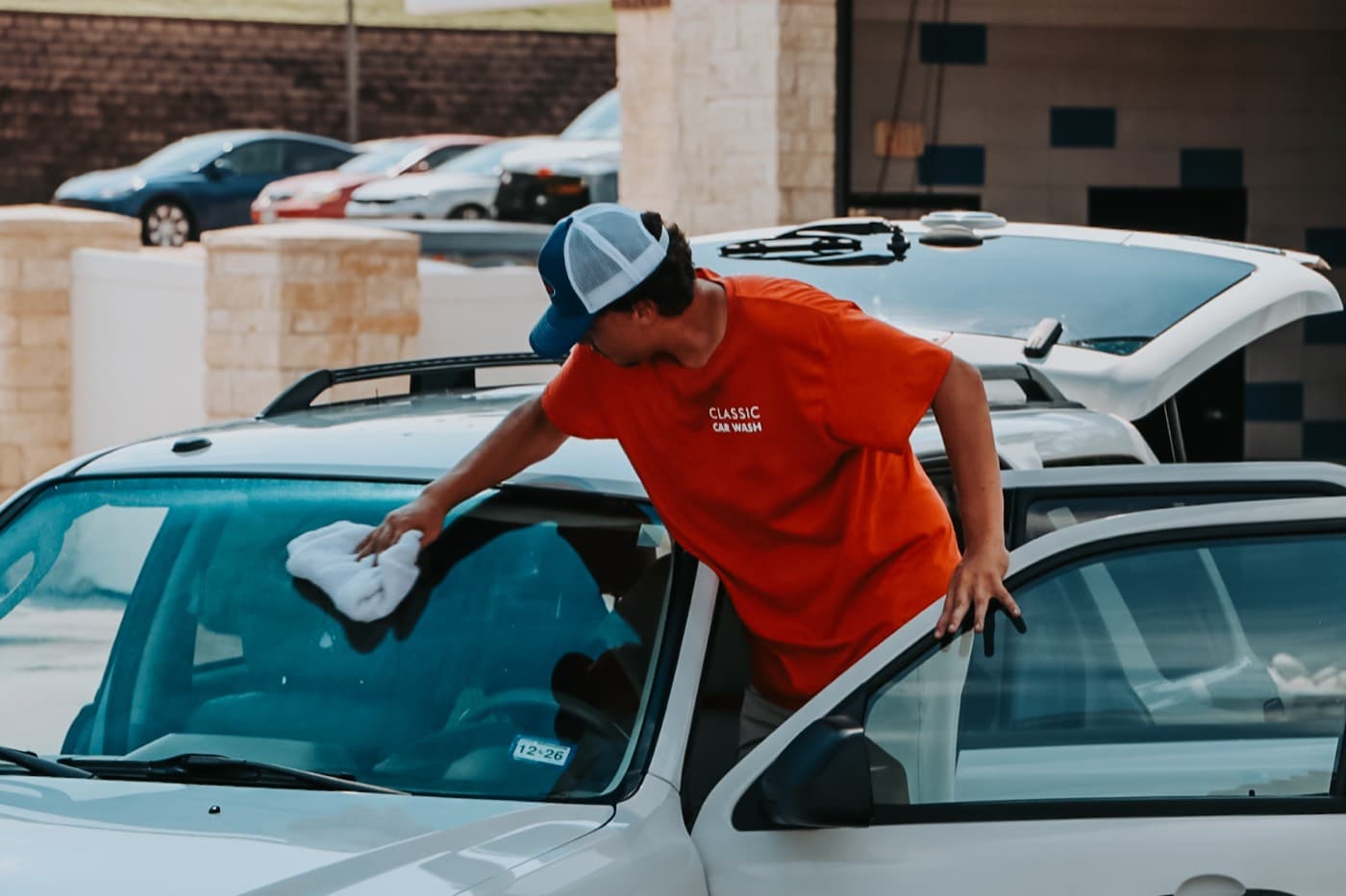 A Classic Car Wash team member hand-drying a vehicle after the wash